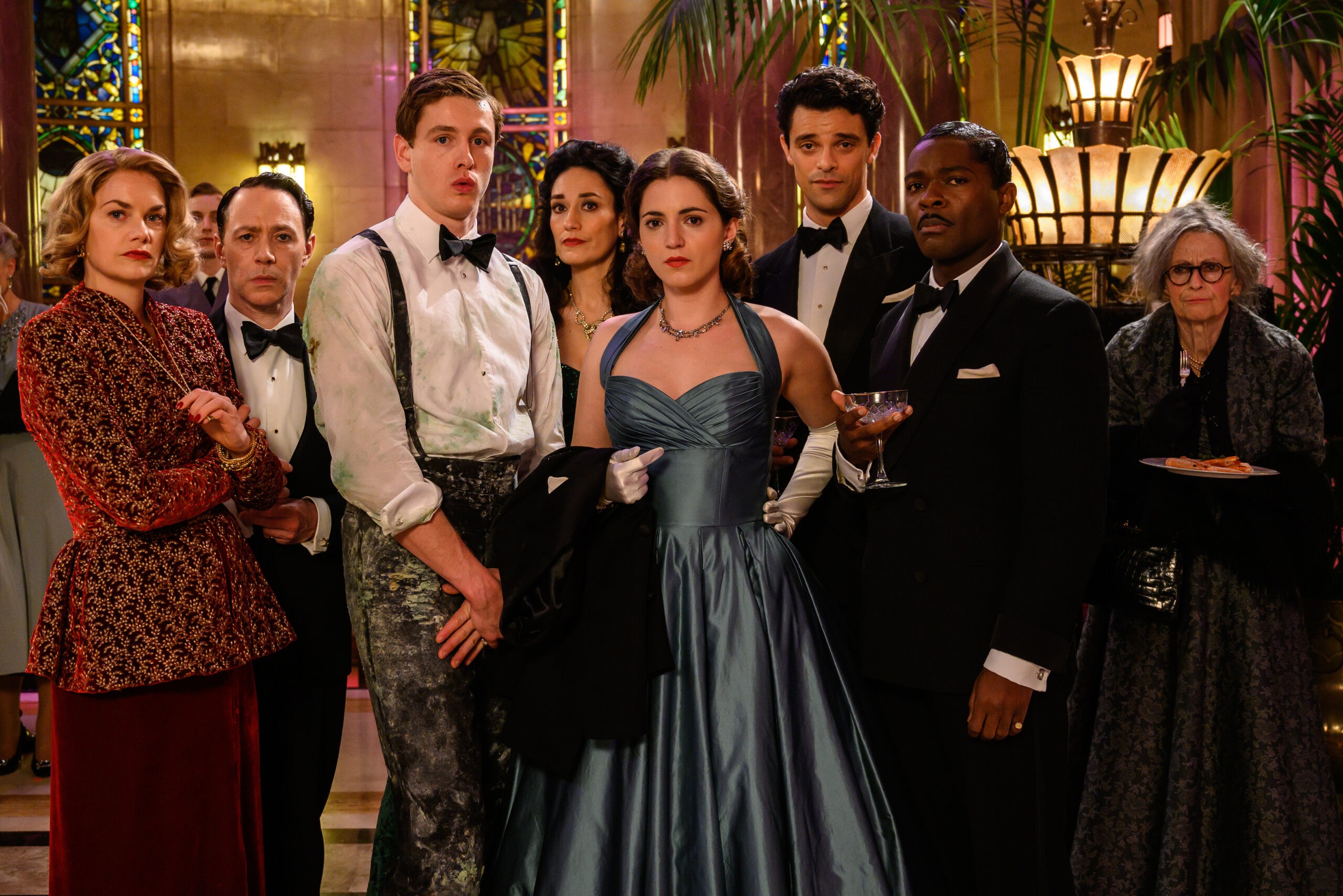 (From L-R): Ruth WIlson, Reece Shearsmith, Harris Dickinson, Sian Clifford, Pearl Chanda, Jacob Fortune Lloyd, David Oyelowo and Ania Marson in the film SEE HOW THEY RUN. Photo by Parisa Taghizadeh. Courtesy of Searchlight Pictures. © 2022 20th Century Studios All Rights Reserved